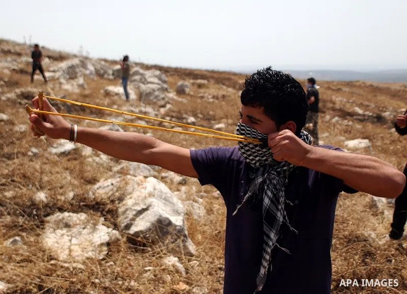 A Palestinian youth uses a sling to hurl stones at Israeli troops during clashes in the village of Iraq Burin near the West Bank city of Nablus on May 21, 2010. Photo by Wagdi Eshtayah