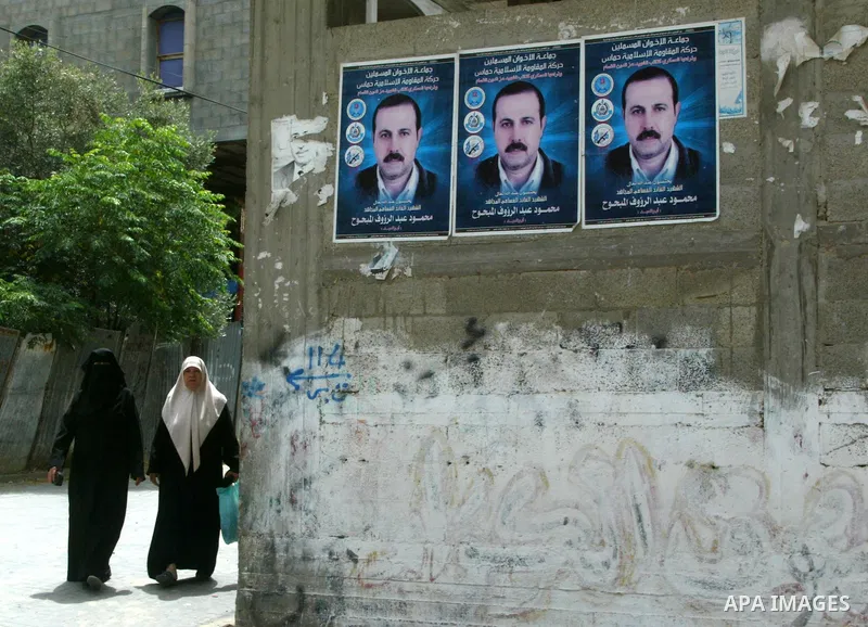 Palestinians walk past a poster image of assassinated senior Hamas militant Mahmoud al-Mabhouh in Jabalya, northern Gaza Strip on May 24, 2010, Australia has ordered the expulsion of an Israeli diplomat working in the Is...