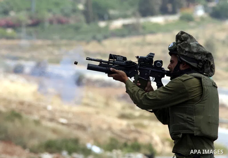 An Israeli soldier fires tear gas canister during clashes with Palestinian protestors in the West Bank village of Nabi Saleh, on 28 May 2010. Palestinians protest weekly against the neighbouring Jewish settlement of Hala...