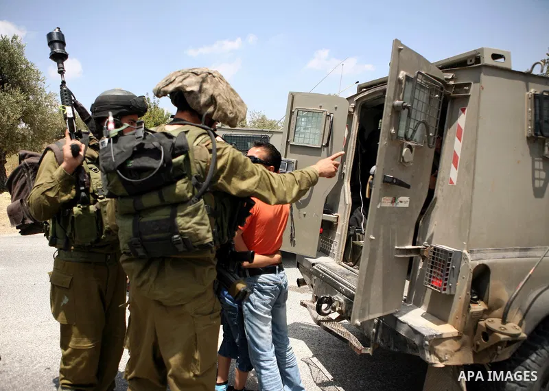 Israeli soldiers detain Palestinian child during clashes in the West Bank village of Nabi Saleh, on 28 May 2010. Palestinians protest weekly against the neighbouring Jewish settlement of Halamish. photo by Eyad Jadallah