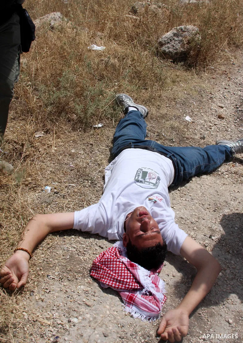 Palestinian, Israeli and foreign activists help wounded protester during a protest against Israel's separation barrier outside the West Bank village of Bilin, near Ramallah, Friday on June 4, 2010. Photo by Wagdi Eshtaya...