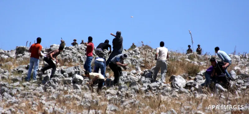 Palestinian youths throw stones at Israeli soldiers during an anti-Israeli demonstration in the West Bank village of Iraq Burin, near the city of Nablus, Saturday, June 5, 2010. Israeli forces seized Saturday the Gaza-bo...