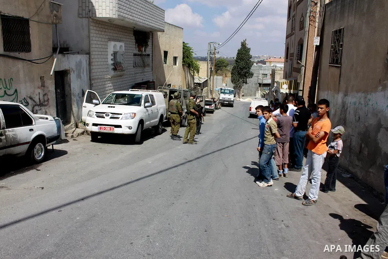 Israeli soldiers inspect a car which was burnt by Jewish settlers in Emateen village near the West Bank city of Nablus on June 10,2010. Photo by Wagdi Eshtayah
