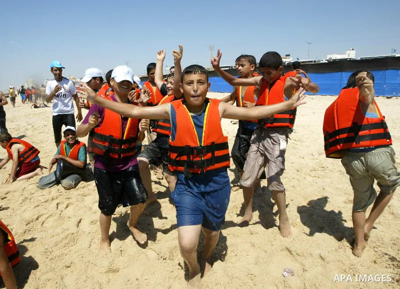 Palestinian boys enjoy at a summer camp run by the United Nations Relief and Works Agency, (UNRWA), on the beach in Gaza City, June 15, 2010. UNRWA has prepared 38 beach locations and 86 schools for its program entitled...
