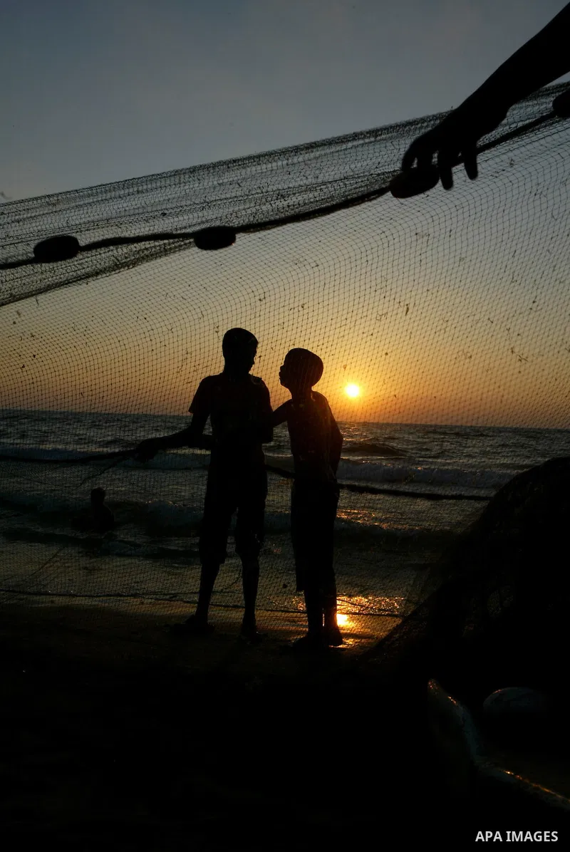 Palestinian fishermen prepare their nets on the beach in Deir al-Balah as the sun sets over the central of Gaza Strip on June 15, 2010. Photo by Ashraf Amra