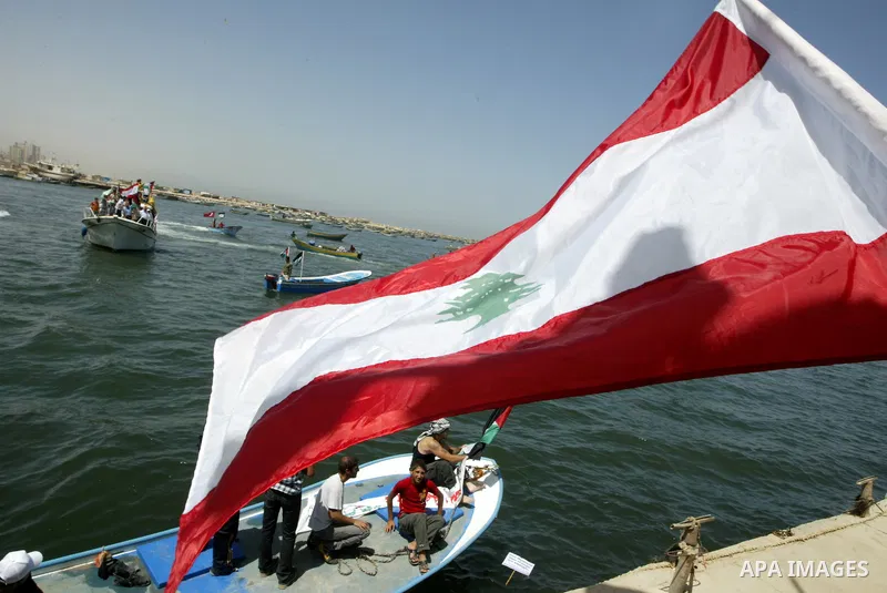 Palestinian and Lebanese flags waving over a fishing boat during a demonstration in support of Lebanese ships planned to sail from Lebanon to Gaza Strip in an attempt to break the Israeli blockade on the Gaza strip, in t...