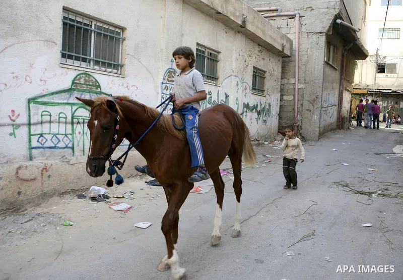 Palestinian children play at Al-Amari refugee camp in the West Bank town of Ramallah, Monday, June 21, 2010. The United Nations High Commission for Refugees marks June 20 as World Refugee Day. Photo by Eyad Jadallah
