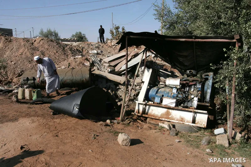 A Palestinian farmer inspects on June 25, 2010 a damaged water well at the scene of a destroyed building following an Israeli air strike overnight on the southern Gaza strip town of Rafah. Photo by Hatem Omar