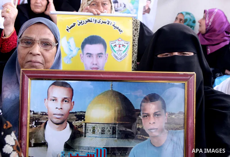 Palestinian women and children hold pictures of jailed relatives during a protest calling for the release of Palestinian prisoners from Israeli jails at the Red Cross office in Gaza City on June 28,2010. Photo by Ali Jad...
