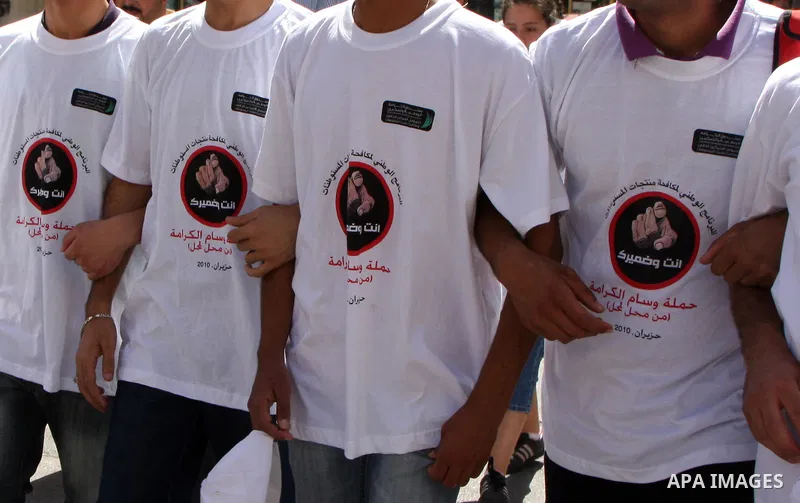 Palestinian volunteers attend a rally as they distribute a guidebook to boycott the settlements products in the West Bank city of Nablus, Monday June 28, 2010. The Palestinian authority launched a campaign of boycotting...