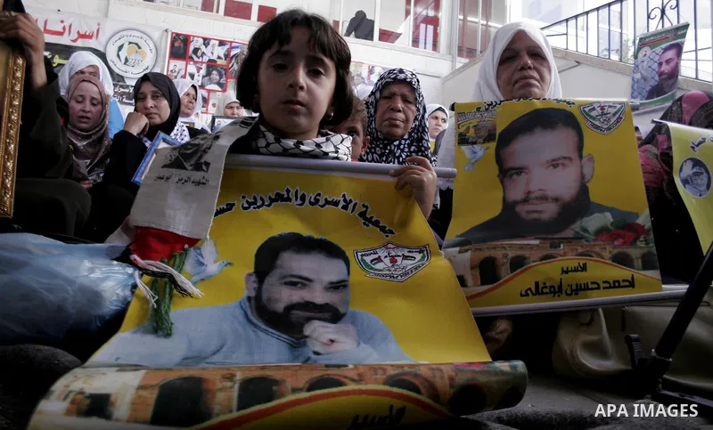 Palestinian women and children hold pictures of jailed relatives during a protest calling for the release of Palestinian prisoners from Israeli jails at the Red Cross office in Gaza City on June 28,2010. Photo by Yousef...