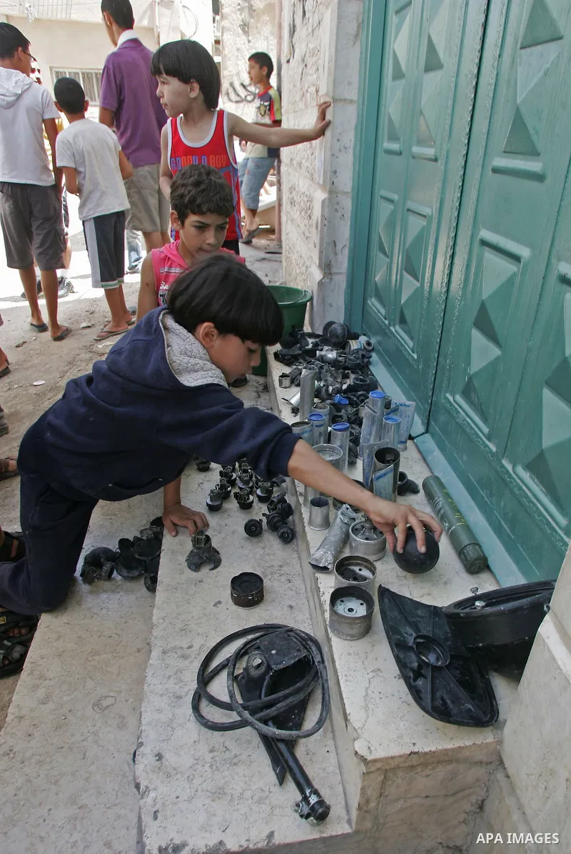 Palestinians collect empty tear gas canisters fired by Israeli soldiers after clashes with Palestinian protesters in the Arab east Jerusalem neighbourhood of Silwan on June 28, 2010. Photo by Mahfouz Abu Turk