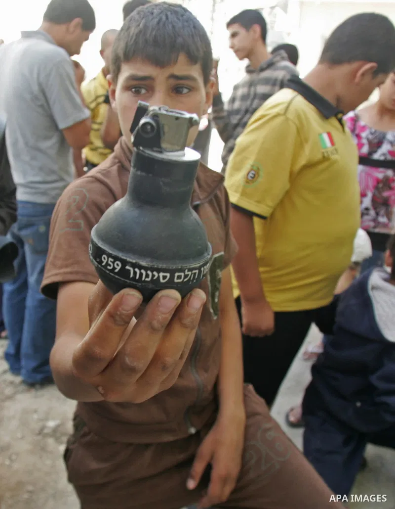 Palestinians collect empty tear gas canisters fired by Israeli soldiers after clashes with Palestinian protesters in the Arab east Jerusalem neighbourhood of Silwan on June 28, 2010. Photo by Mahfouz Abu Turk