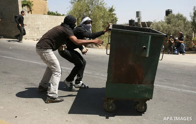 A Palestinian youth throws stones at Israeli soldiers during clashes following a protest in Nabi Saleh, near Ramallah, on July 2, 2010 against the expropriation of Palestinian land to expand the nearby Jewish settlement...