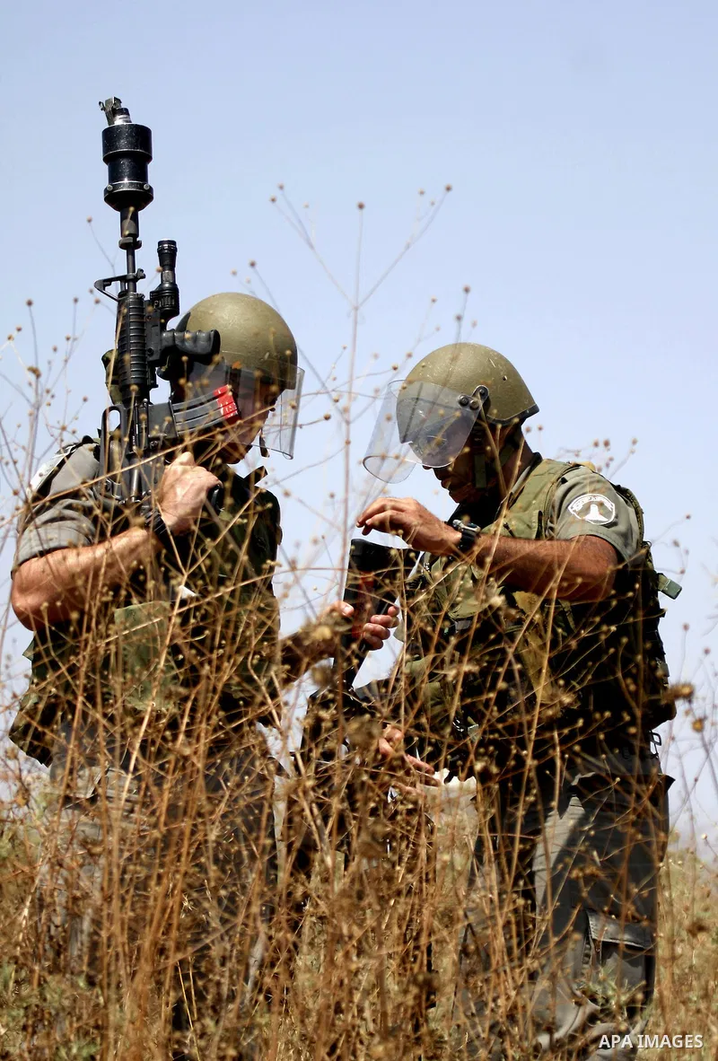 An Israeli soldier prepares to fire tear gas canister during a protest by Palestinian and foreign protesters against the expansion of the Israeli settlements at Nabi Salah village near the West Bank City of Ramallah, on...