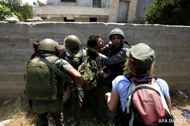 Israeli soldiers arrest a protester during a protest against the expansion of the Israeli settlements at Nabi Salah village near the West Bank City of Ramallah, on 09 July 2010. Photo by Eyad Jadallah