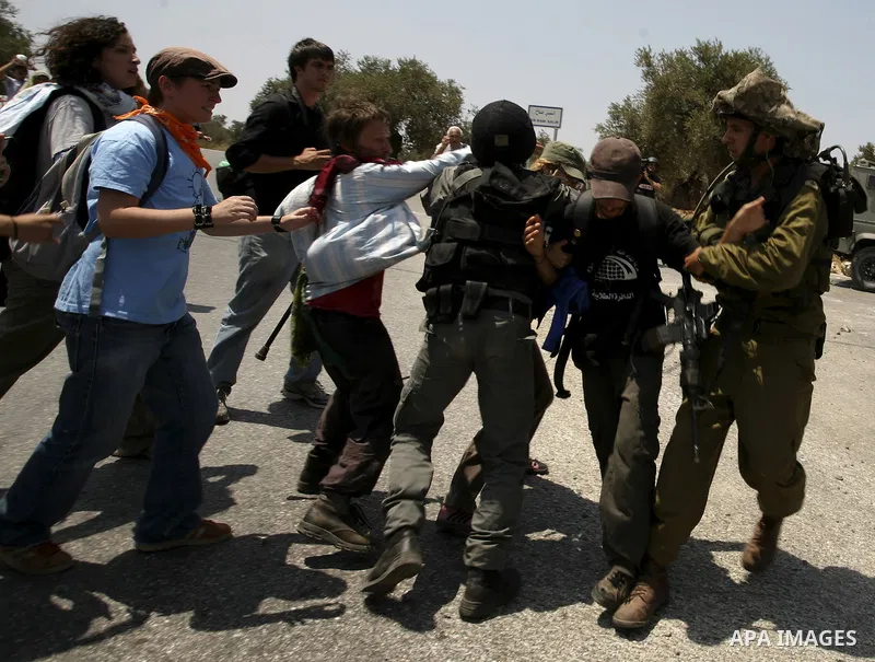 Israeli soldiers arrest a protester during a protest against the expansion of the Israeli settlements at Nabi Salah village near the West Bank City of Ramallah, on 09 July 2010. Photo by Eyad Jadallah