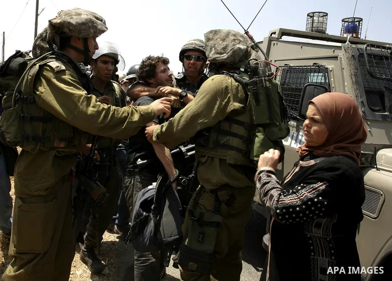 Israeli soldiers arrest a protester during a protest against the expansion of the Israeli settlements at Nabi Salah village near the West Bank City of Ramallah, on 09 July 2010. Photo by Eyad Jadallah