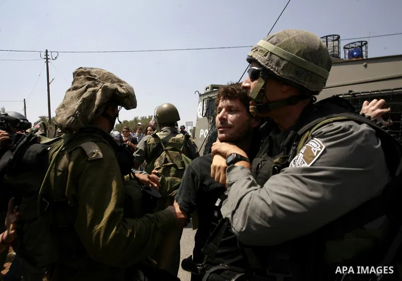 Israeli soldiers arrest a protester during a protest against the expansion of the Israeli settlements at Nabi Salah village near the West Bank City of Ramallah, on 09 July 2010. Photo by Eyad Jadallah