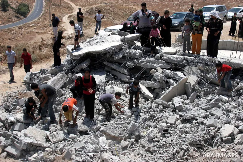 Palestinians inspect a demolished house in the village of Al-Samoua near the West Bank city of Hebron on July 15 2010. The Israeli government claimed that the houses that were demolished were not licensed, but the homeow...