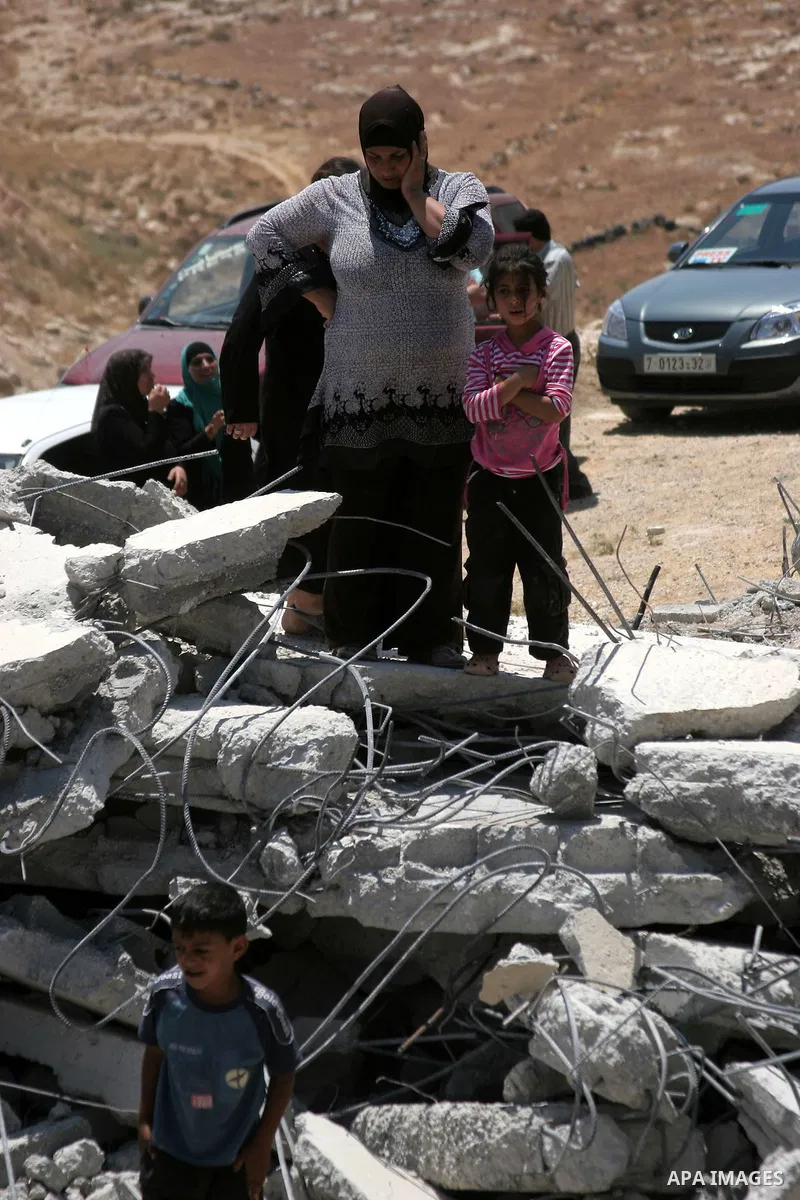 Palestinians inspect a demolished house in the village of Al-Samoua near the West Bank city of Hebron on July 15 2010. The Israeli government claimed that the houses that were demolished were not licensed, but the homeow...