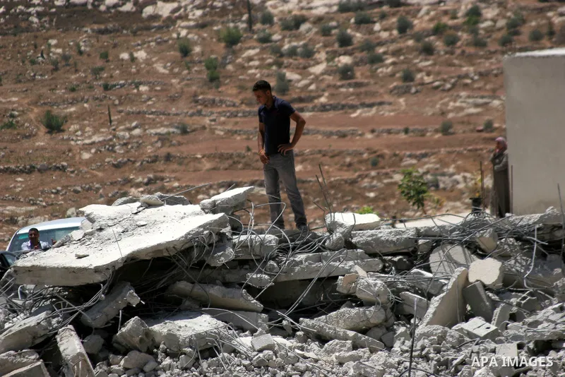 Palestinians inspect a demolished house in the village of Al-Samoua near the West Bank city of Hebron on July 15 2010. The Israeli government claimed that the houses that were demolished were not licensed, but the homeow...