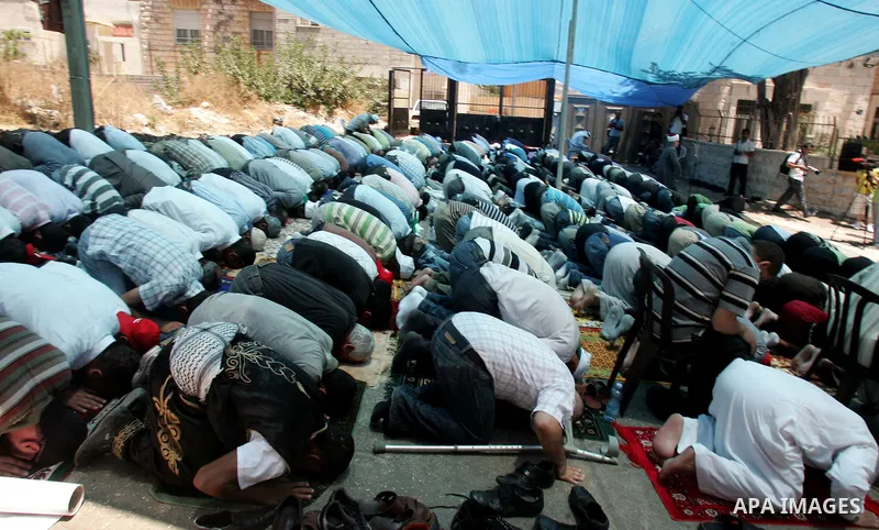 Palestinians pray in the Red Cross yard during the Friday prayer in East Jerusalem , Friday 16 July 2010, in solidarity with PLC members and former Palestinian minister Ahmad Atwon, Mohammad Totah and Khalid Abu Arfeh. A...