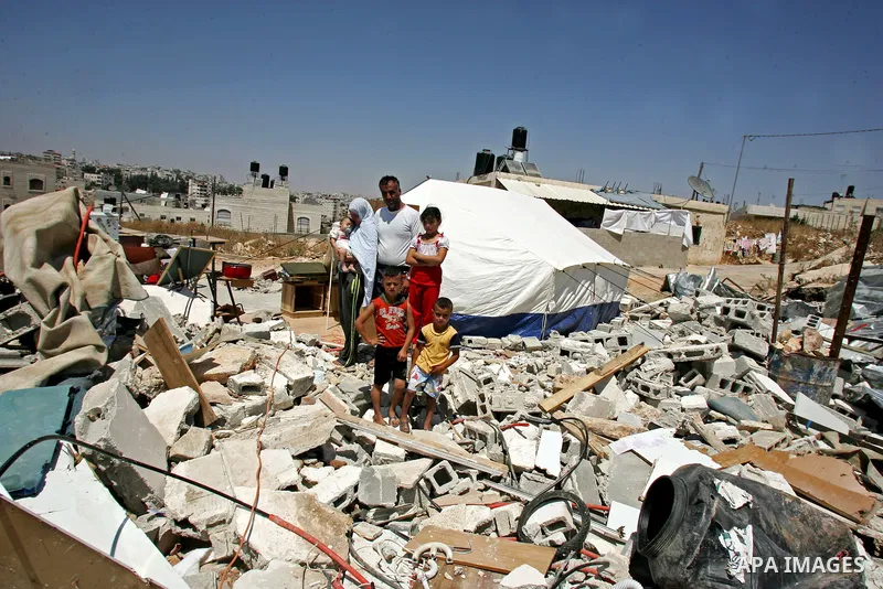 Palestinian family stand near a tent on the rubbles of their home in the Arab neighborhood of Beit Hanina in occupied east Jerusalem on July 17,2010 after Israeli army bulldozers destroyed their home. Al Rajabi family wh...