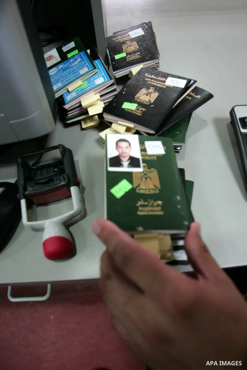 Hamas police officers check passports of Palestinians waiting to leave the crossing between Egypt and Gaza at Rafah, southern Gaza Strip on July 19, 2010. Number from Palestinians are heading to the holy places in Saudi...