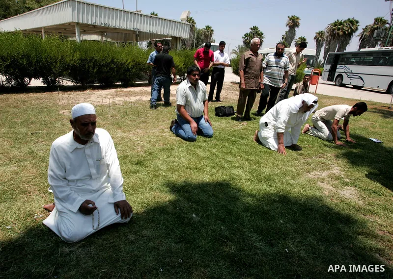 Palestinians pray while they wait to leave the crossing between Egypt and Gaza at Rafah, southern Gaza Strip on July 19, 2010. Palestinians are heading to the holy places in Saudi Arabia for Umrah annual. Photo by Khaled...