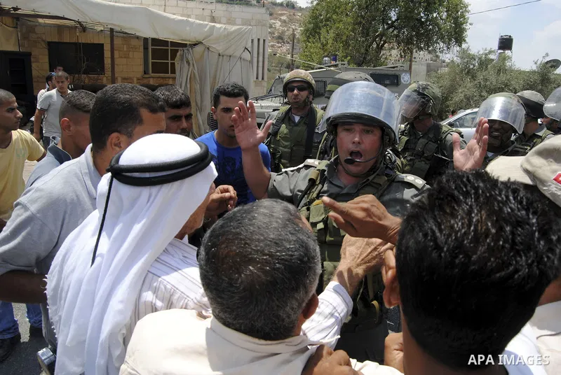 Palestinians scuffle with Israeli soldiers in the West Bank village of Lubban al-Gharbia on July 21, 2010 after Israeli forces demolished two houses and four shops that were built without the army's permit near a road le...