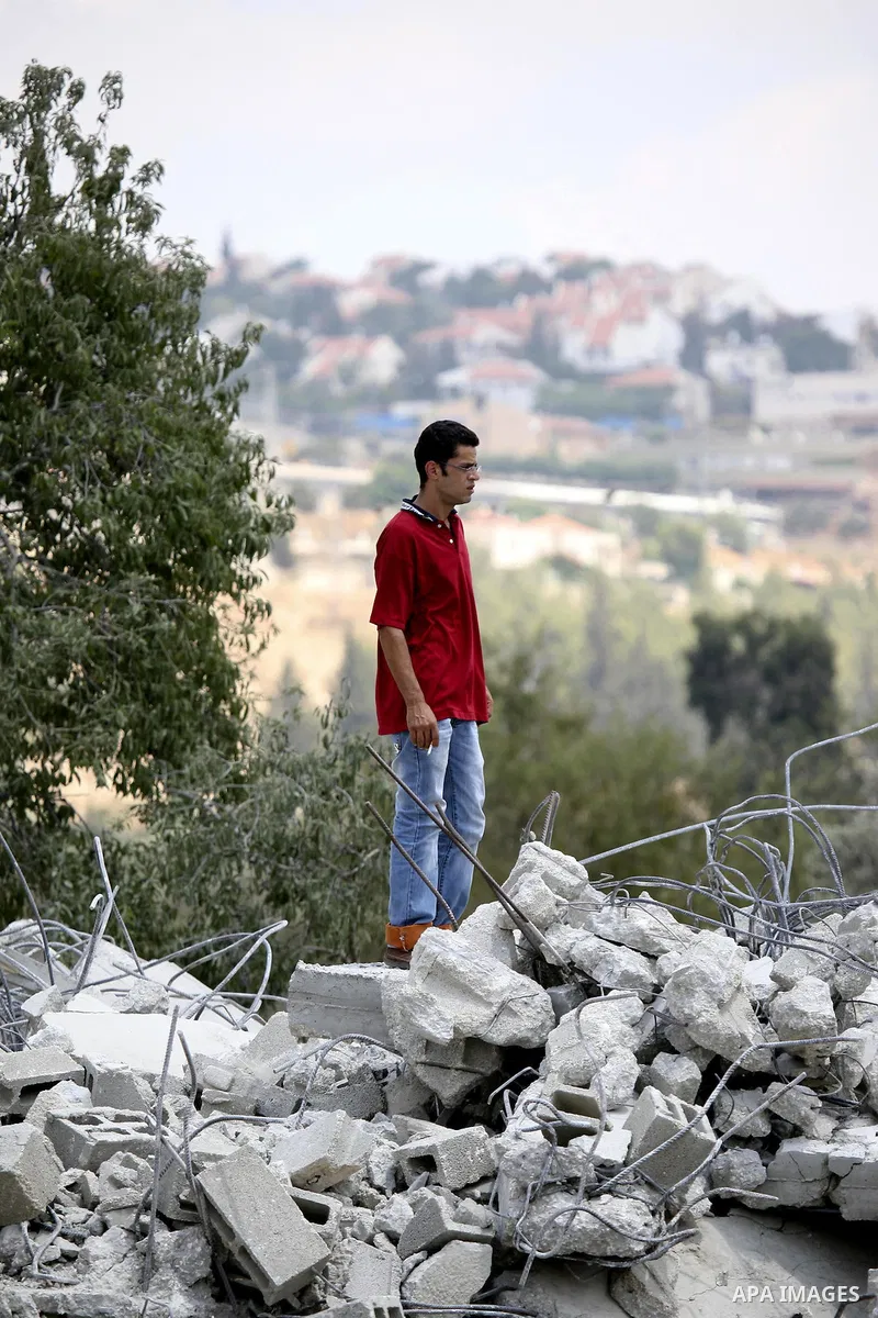 A Palestinian youth stands on the rubble of a house in the West Bank village of Lubban al-Gharbia on July 21, 2010 after Israeli forces demolished two houses and four shops that were built without the army's permit near...