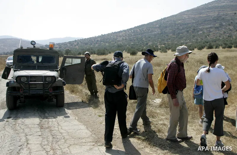 Israeli soldiers prevent Israeli activists from entering the village of Awarta in order to help Palestinian farmers to plant olive trees near the West Bank city of of Nablus, Thursday, July, 22, 2010. Israel's military s...
