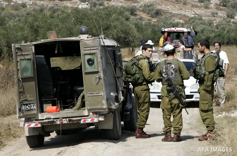 Israeli soldiers prevent Israeli activists from entering the village of Awarta in order to help Palestinian farmers to plant olive trees near the West Bank city of of Nablus, Thursday, July, 22, 2010. Israel's military s...