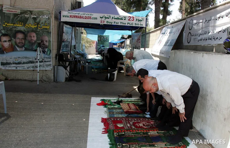 Palestinians pray in the Red Cross yard during the Friday prayer in East Jerusalem , Friday 23 July 2010, in solidarity with PLC members and former Palestinian minister Ahmad Atwon, Mohammad Totah and Khalid Abu Arfeh. A...