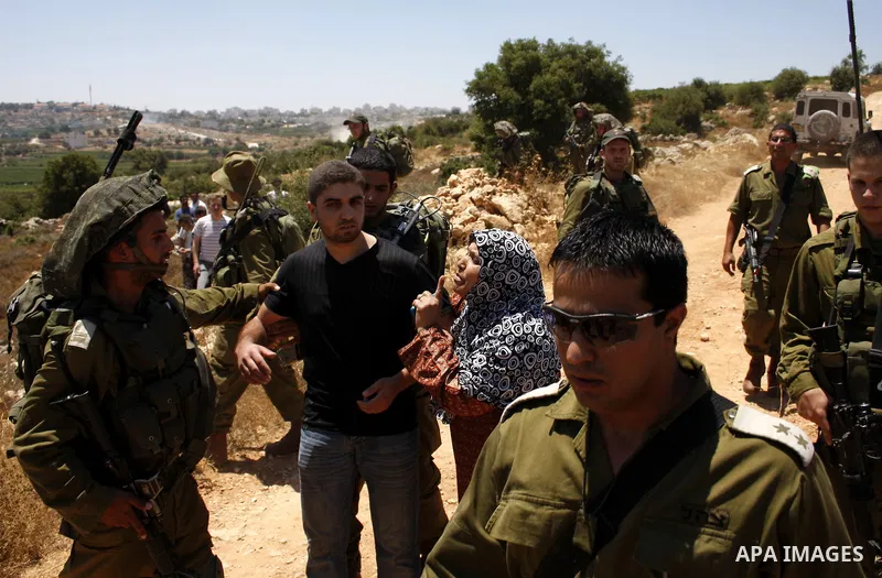 Armed Jewish ideological settlers set up tents on Palestinian land as they try to establish a new outpost near the Israeli settlement of Kharsina on 23 July 2010 east of Hebron, in the occupied West Bank. Photo by Mamoun...