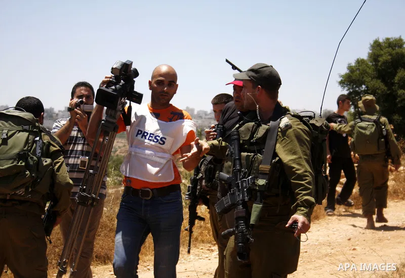 A Palestinian cameraman argues with Israeli forces as he is taken away from his land which has been occupied by tents of armed Jewish ideological settlers (unseen) who are setting up a new outpost near the Israeli settle...