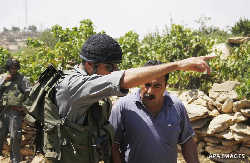 An Israeli soldier argues with a Palestinian protester during a demonstration against Israel's controversial separation barrier in the village of Beit Omar near Jewish settlement of Karmi zur near the West Bank city of H...