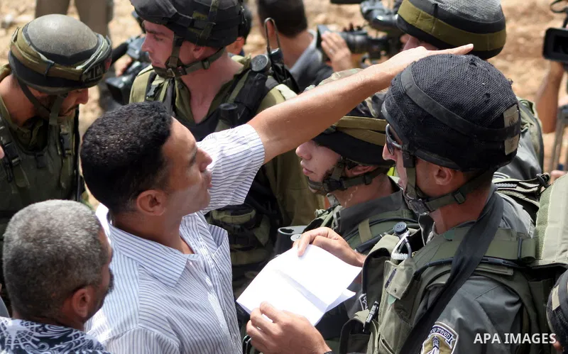 Israeli soldiers argue with Palestinian protesters during a demonstration against Israel's controversial separation barrier in the village of Beit Omar near Jewish settlement of Karmi zur near the West Bank city of Hebro...