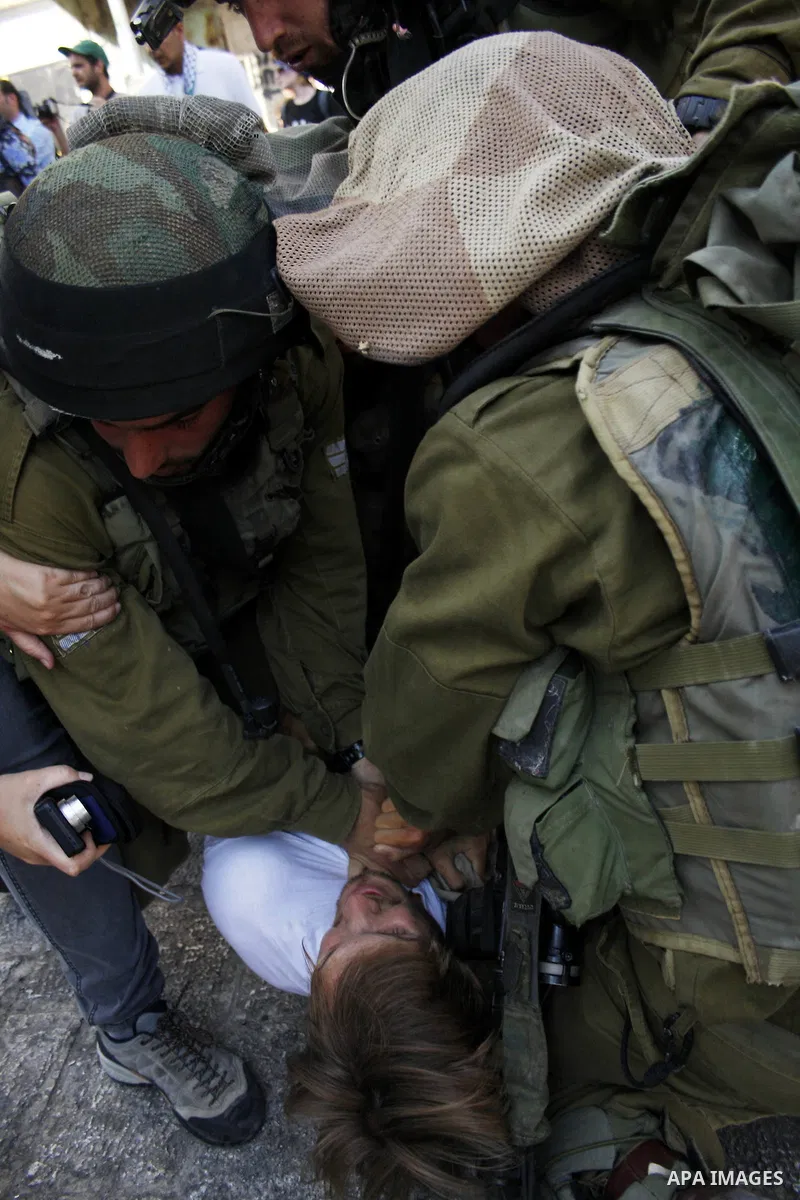 Israeli soldiers arrest a foreign demonstrator during the weekly protest against the closing of Al-Shuhada Street in the West Bank old city of Hebron on July 24,2010. Palestinians, Israelis and International peace activi...