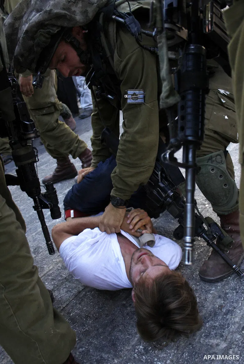 Israeli soldiers arrest a foreign demonstrator during the weekly protest against the closing of Al-Shuhada Street in the West Bank old city of Hebron on July 24,2010. Palestinians, Israelis and International peace activi...