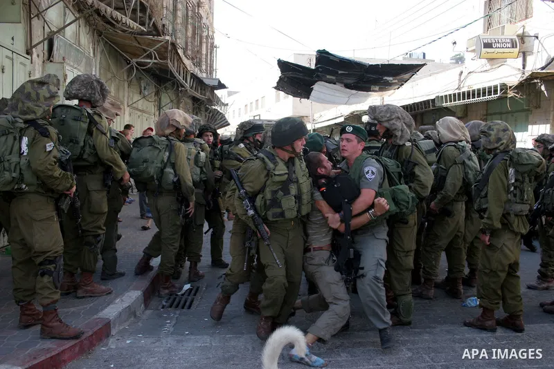 Israeli soldiers arrest a foreign demonstrator during the weekly protest against the closing of Al-Shuhada Street in the West Bank old city of Hebron on July 24,2010. Palestinians, Israelis and International peace activi...