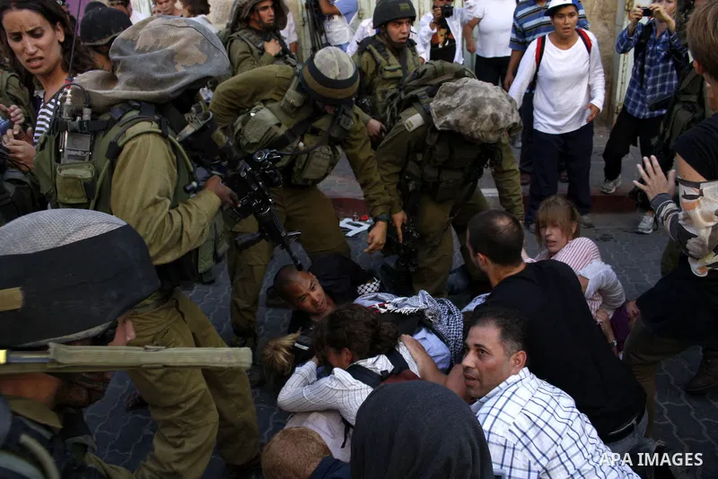 Israeli soldiers arrest foreign demonstrators during the weekly protest against the closing of Al-Shuhada Street in the West Bank old city of Hebron on July 24,2010. Palestinians, Israelis and International peace activis...