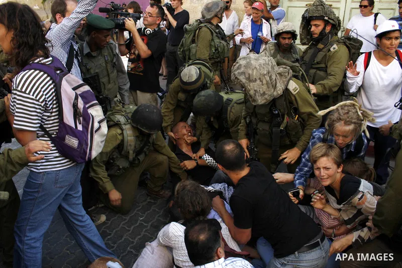 Israeli soldiers arrest foreign demonstrators during the weekly protest against the closing of Al-Shuhada Street in the West Bank old city of Hebron on July 24,2010. Palestinians, Israelis and International peace activis...