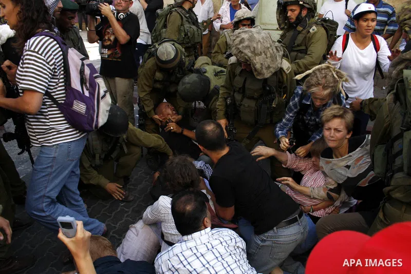 Israeli soldiers arrest foreign demonstrators during the weekly protest against the closing of Al-Shuhada Street in the West Bank old city of Hebron on July 24,2010. Palestinians, Israelis and International peace activis...