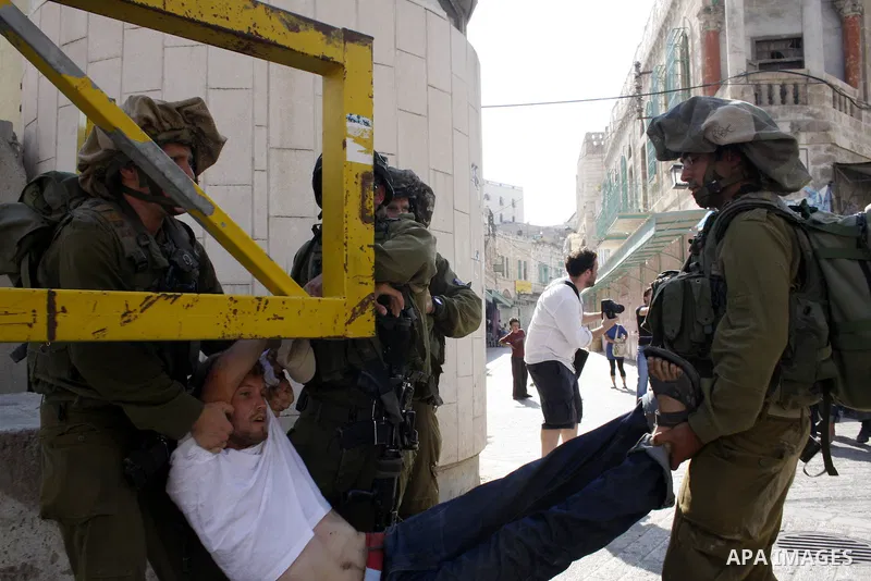 Israeli soldiers arrest a foreign demonstrator during the weekly protest against the closing of Al-Shuhada Street in the West Bank old city of Hebron on July 24,2010. Palestinians, Israelis and International peace activi...
