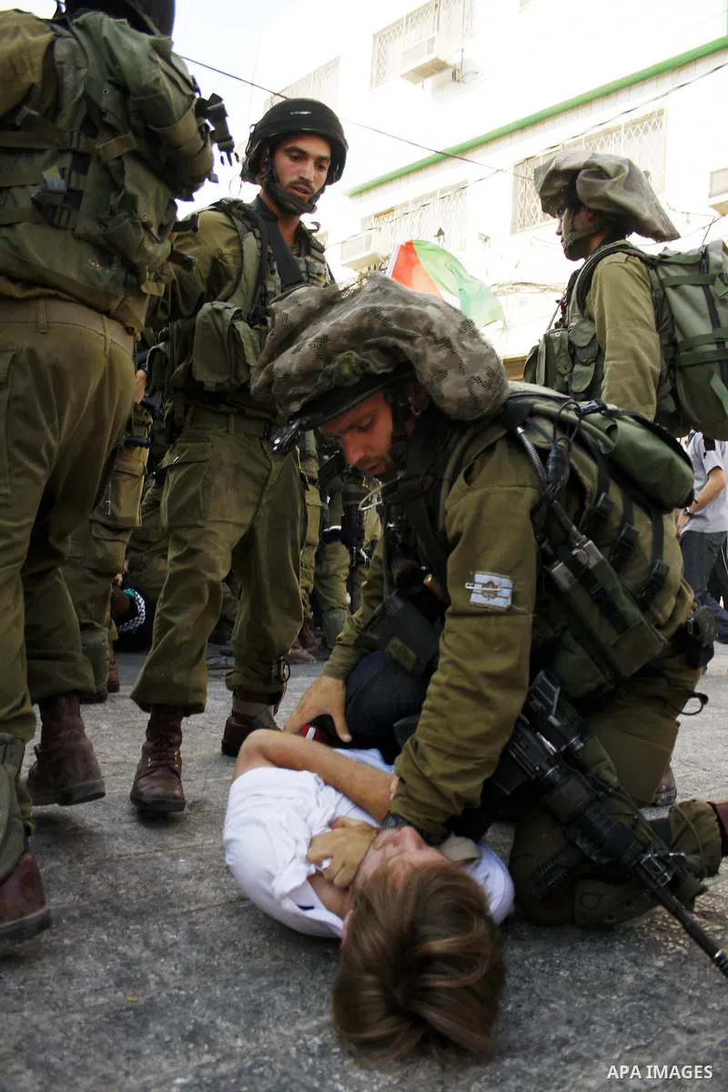 Israeli soldiers arrest a foreign demonstrator during the weekly protest against the closing of Al-Shuhada Street in the West Bank old city of Hebron on July 24,2010. Palestinians, Israelis and International peace activi...