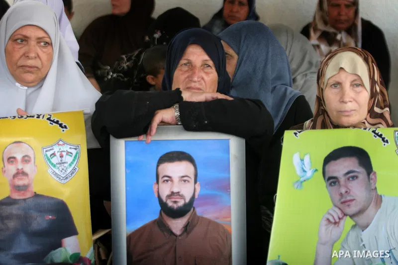 Palestinian women hold pictures of jailed relatives during a protest calling for the release of Palestinian prisoners from Israeli jails at the Red Cross office in Gaza City on July 26,2010. Photo by Ali Jadallah