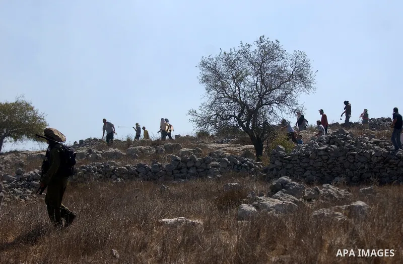 Jewish settlers sling rocks towards Palestinians during clashes close to the northern West Bank village of Burin on July 26, 2010, which began when Israeli troops removed two mobile homes set up near the Bracha settlemen...