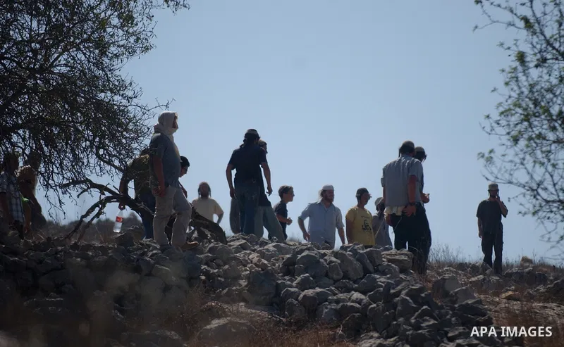 Jewish settlers sling rocks towards Palestinians during clashes close to the northern West Bank village of Burin on July 26, 2010, which began when Israeli troops removed two mobile homes set up near the Bracha settlemen...